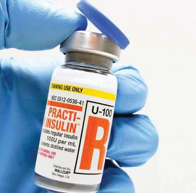 Practi-Insulin training vial held in a gloved hand